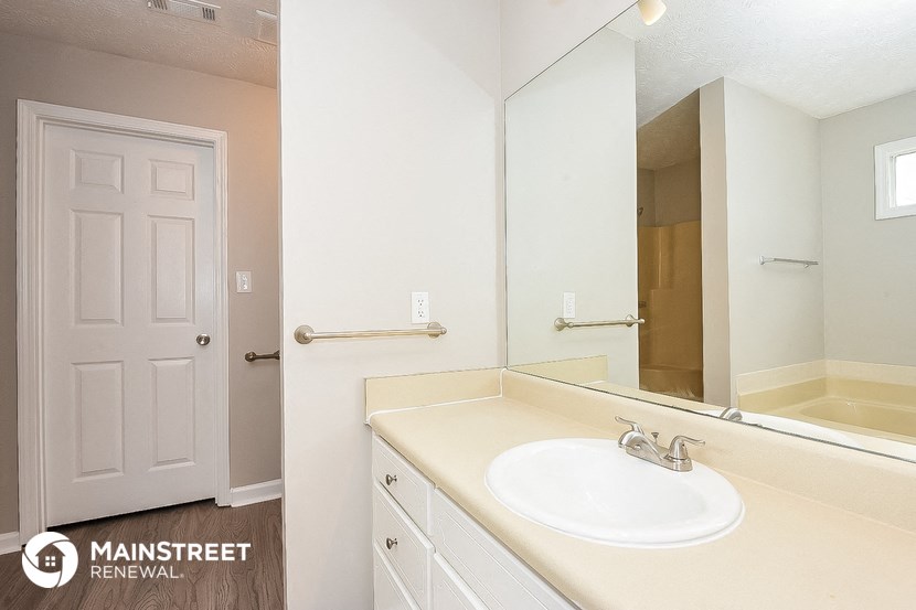 a bathroom with a white sink and a large mirror