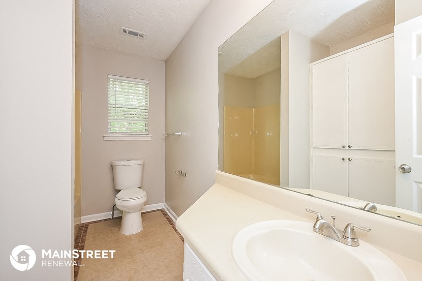 a bathroom with a sink and a toilet and a mirror