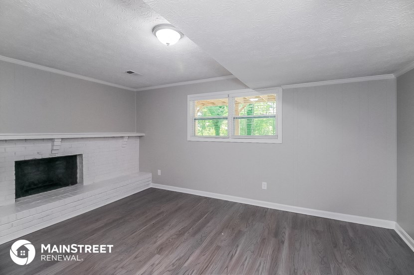 the living room of a renovated house with a fireplace