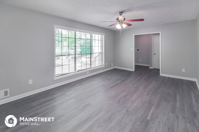 the living room of an empty house with a ceiling fan