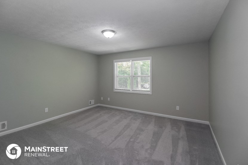 the interior of an empty room with gray walls and a window