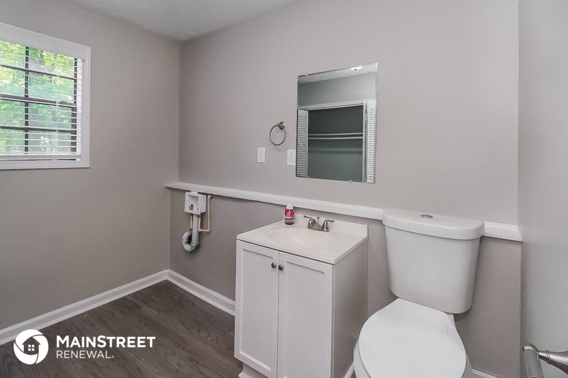 a bathroom with a toilet and a sink and a mirror