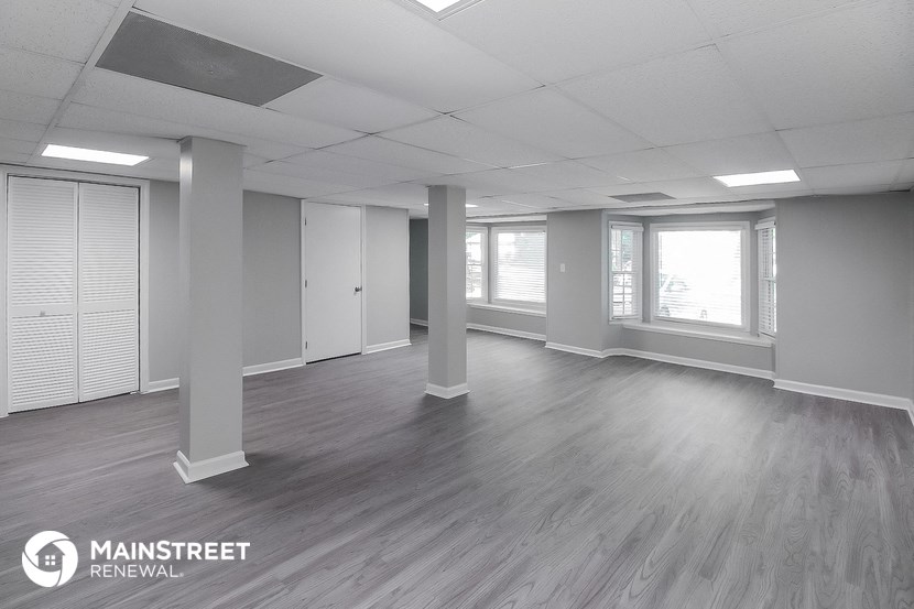 an empty living room with white walls and wood floors