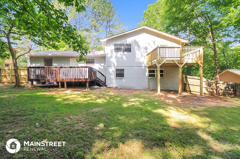 a white house with a porch and a deck on the side