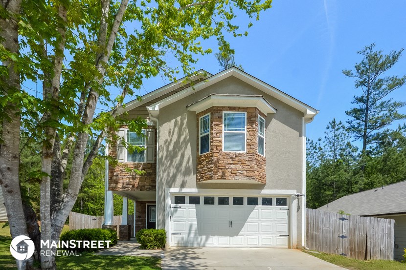 a tan house with a white garage door