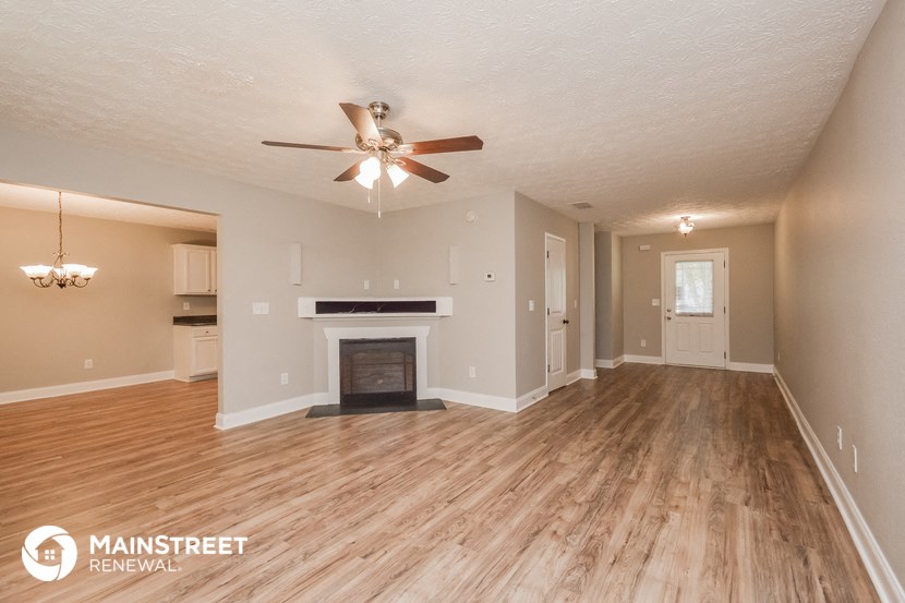 a living room with a fireplace and a ceiling fan