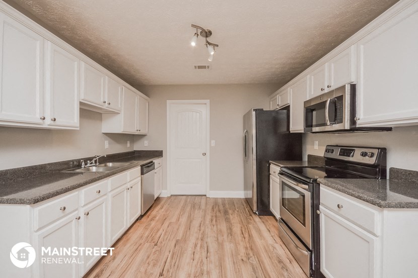 a kitchen with white cabinets and stainless steel appliances