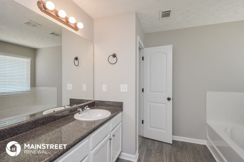 a bathroom with a sink and a mirror and a white door