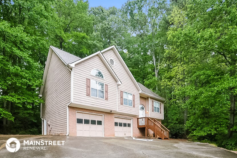 the front of a house with trees in the background