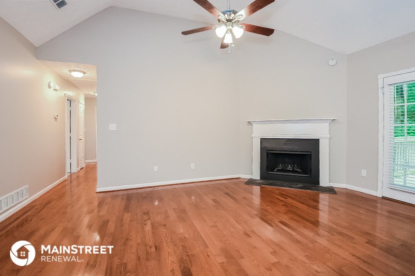 the living room with wood flooring and fireplace