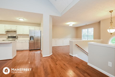 a kitchen with white cabinets and a stainless steel refrigerator