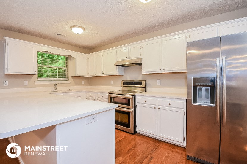 a white kitchen with stainless steel appliances and white cabinets