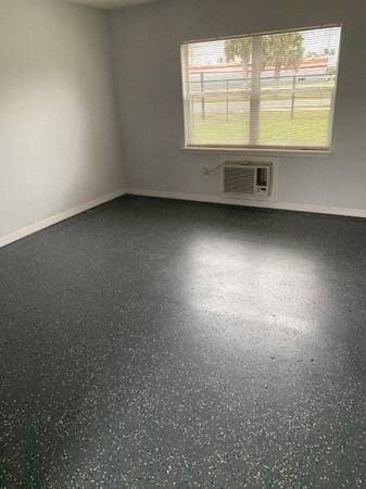 an empty room with a window and a black and white floor