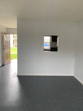 an empty living room with a window in the wall