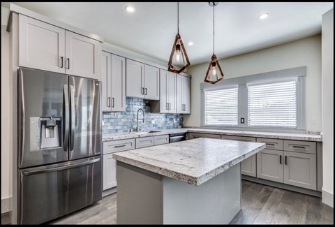 a kitchen with white cabinets and stainless steel appliances