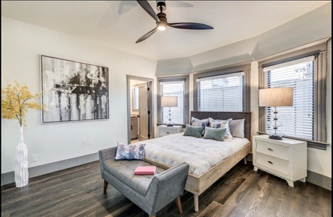 a bedroom with a large bed and a ceiling fan