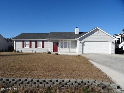 a white house with red doors and a driveway