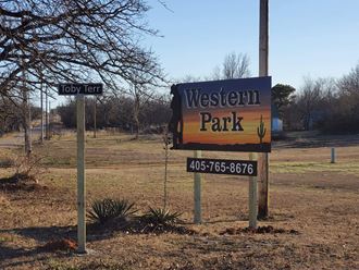 a sign for western park in front of a field