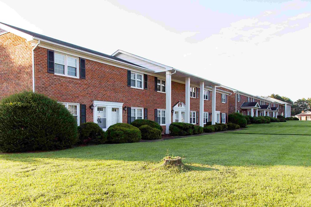 a large brick building with a lawn in front of it