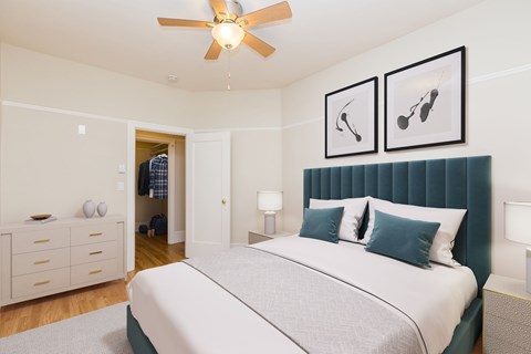 A bedroom with a bed, nightstands, and a ceiling fan.