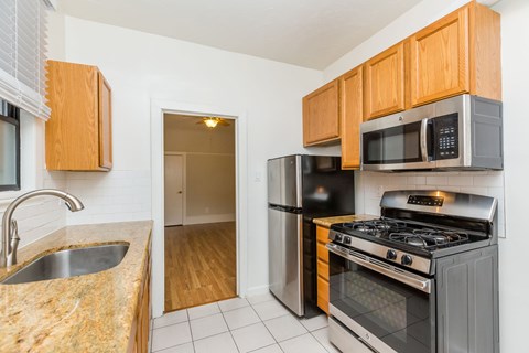 A kitchen with a sink, stove, and refrigerator.