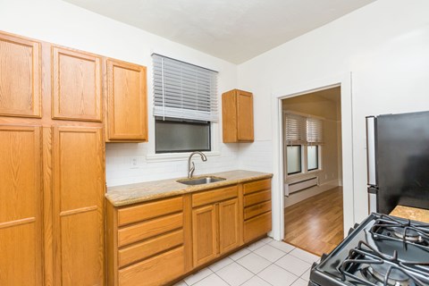 A kitchen with wooden cabinets and a black stove top.