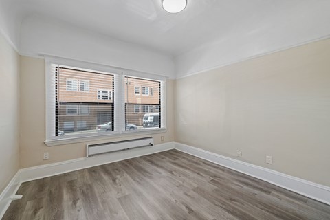 A room with a window and wooden flooring.