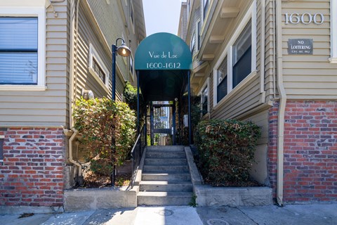 A green sign that says "Vue de Loc 1600-1612" is in front of a building.