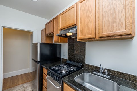 A kitchen with wooden cabinets and black appliances.