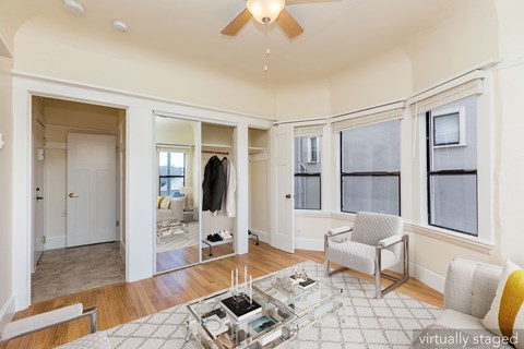 A spacious living room with a glass coffee table in the center.
