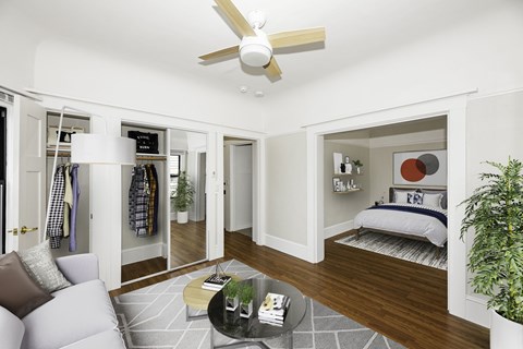 A well-lit, spacious bedroom with a large bed and a separate sitting area.