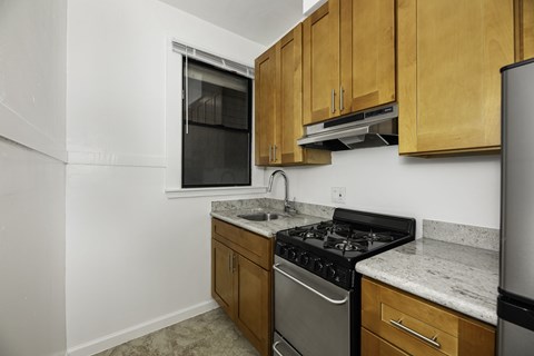 A kitchen with wooden cabinets and a marble countertop.