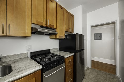 A kitchen with a black stove top oven and a black refrigerator.