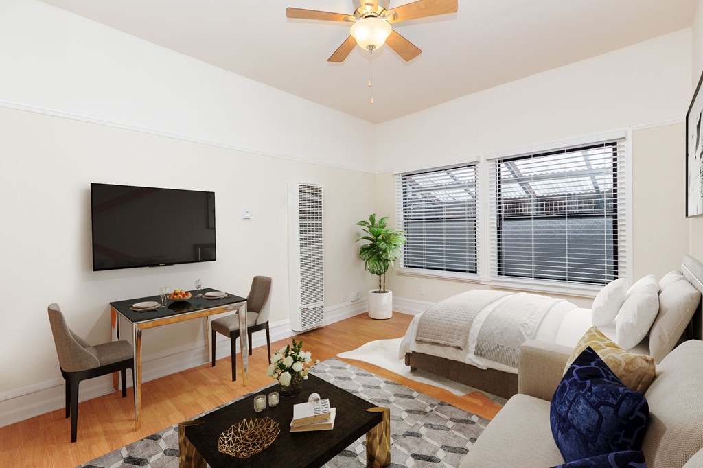 a bedroom with a bed and a desk and a tv