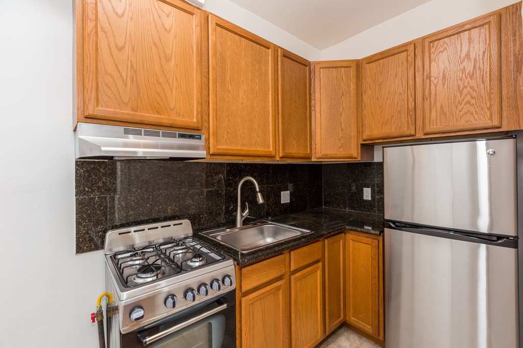 a kitchen with wooden cabinets and a stove and refrigerator