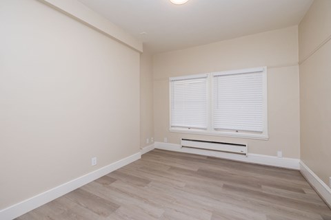 A room with a window and a bench under the window.