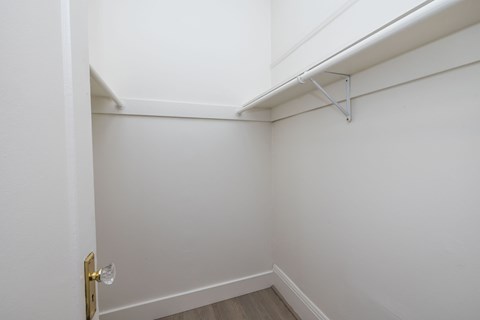 A white door with a gold handle is on the left side of a white wall.