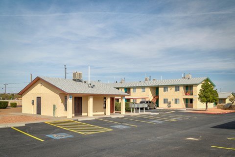 A parking lot in front of a building with a yellow and blue painted parking space.