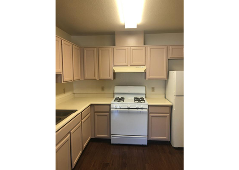 A white stove in a kitchen with wooden cabinets.