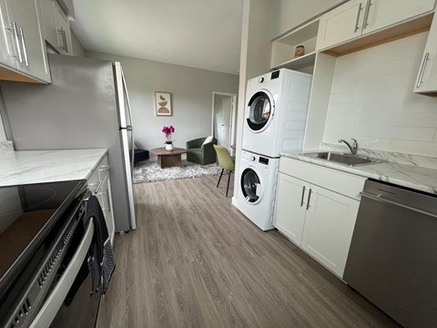 A modern kitchen with a washing machine built into the cabinetry.