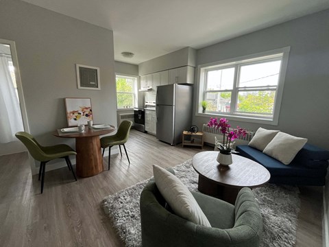 A modern living room with a dining table and chairs.
