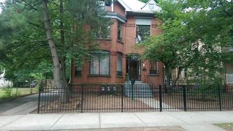 a brick house with a black fence in front of it