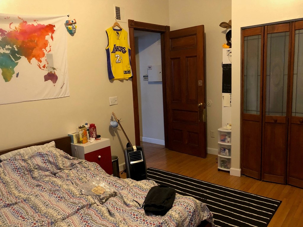 a bedroom with a bed and a door to a closet