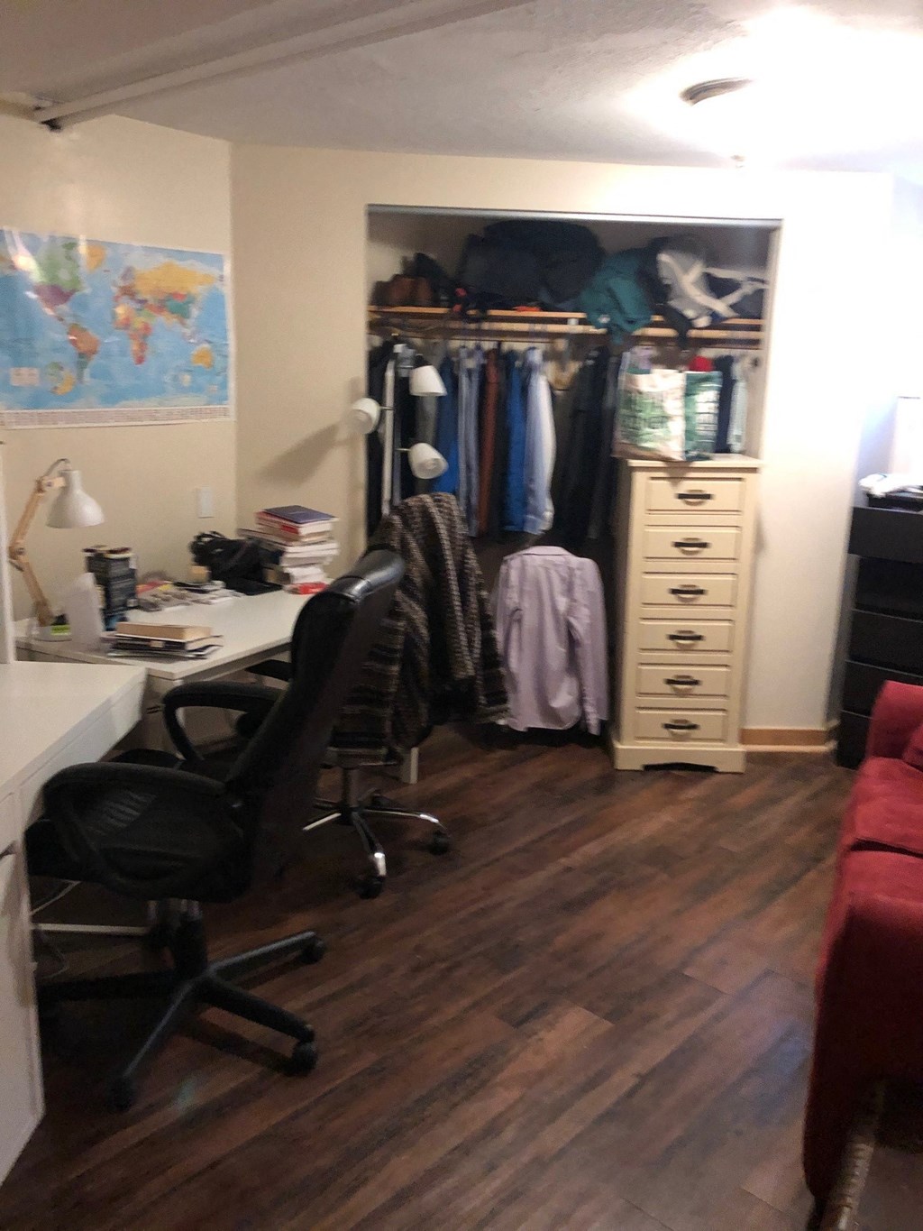 a closet in a small room with a desk and a chair