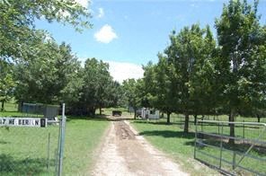 A dirt road leads to a white building with a sign that says "17 ME BERN".