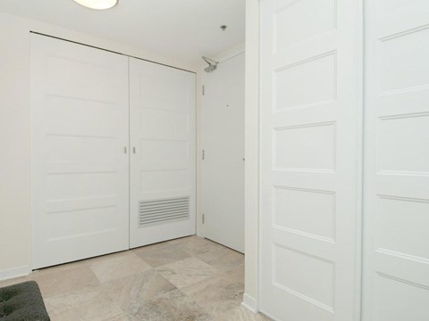 A room with white doors and a tiled floor.