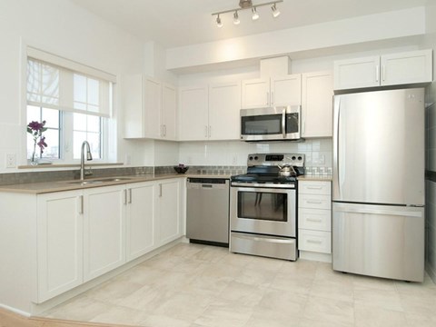 A kitchen with white cabinets and stainless steel appliances.