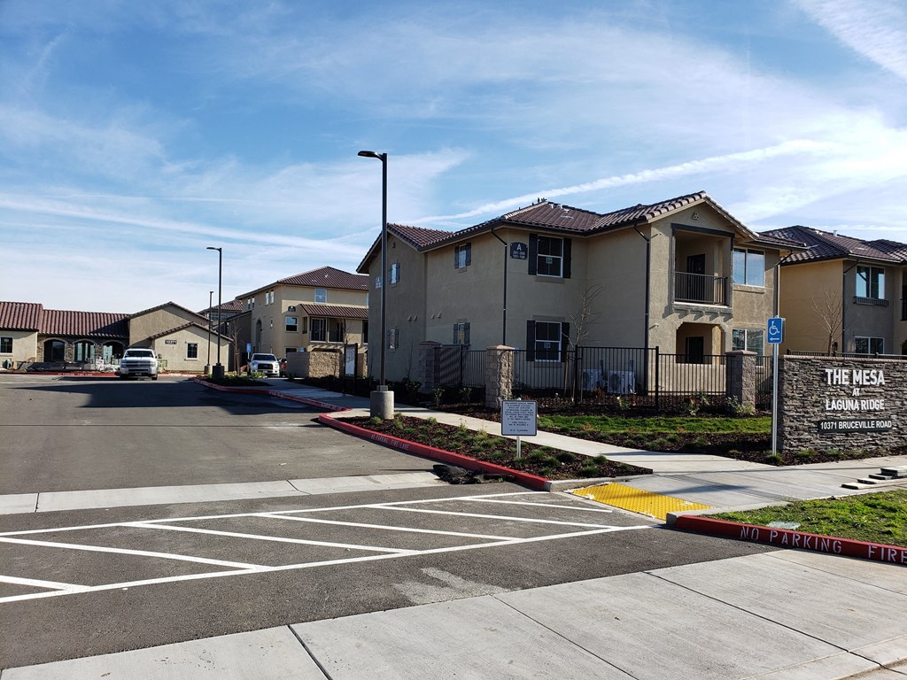 an empty parking lot in front of an apartment building