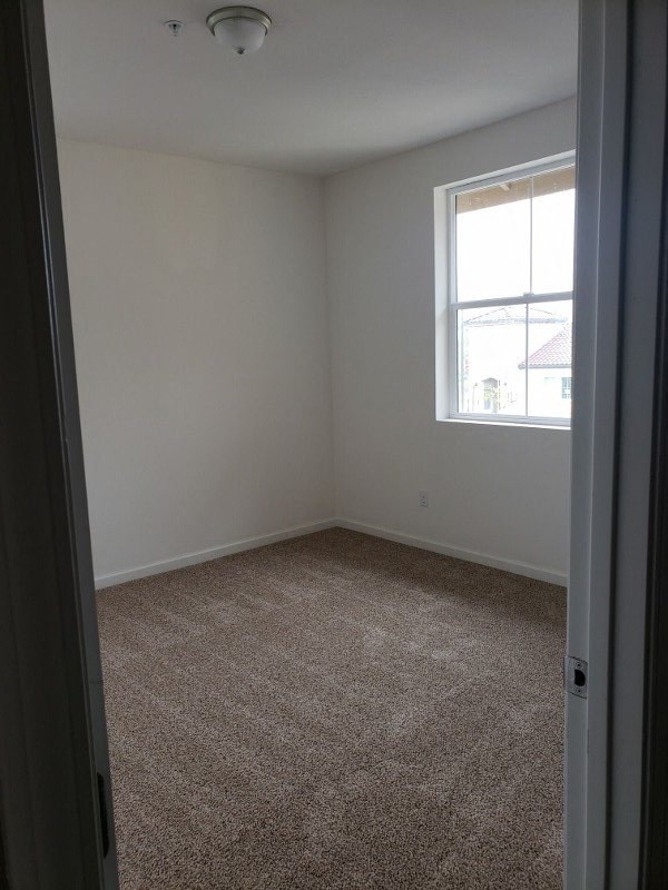 an empty room with a window and a carpet