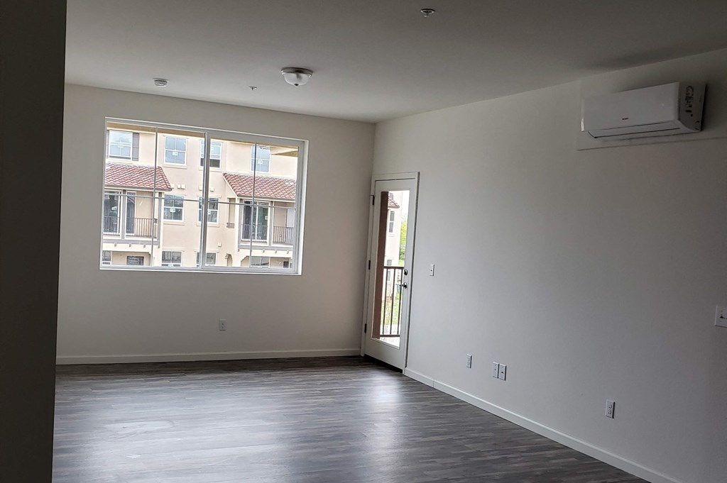 an empty living room with a window and a door